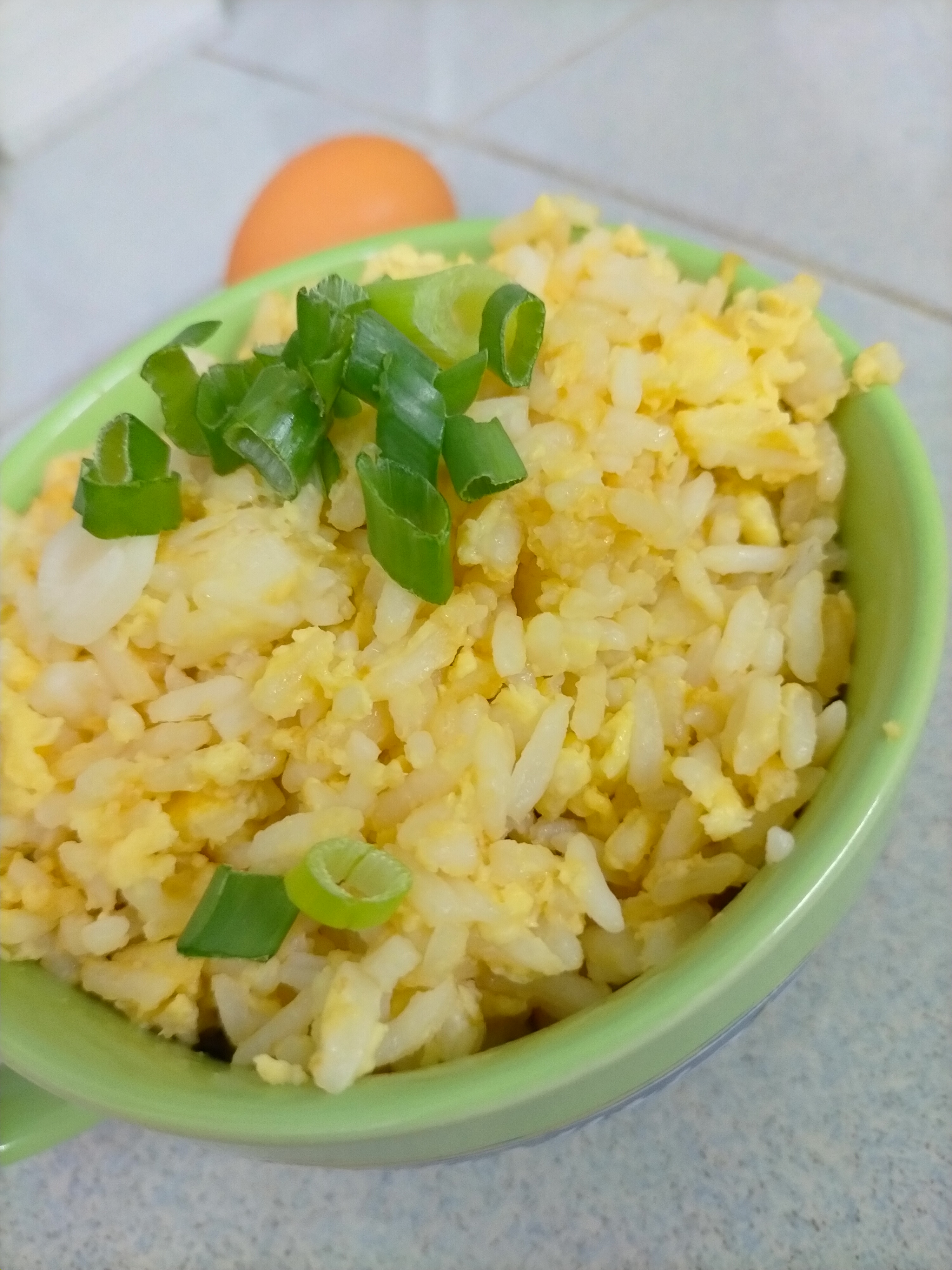 Chinese egg fried rice with scallions in a bowl