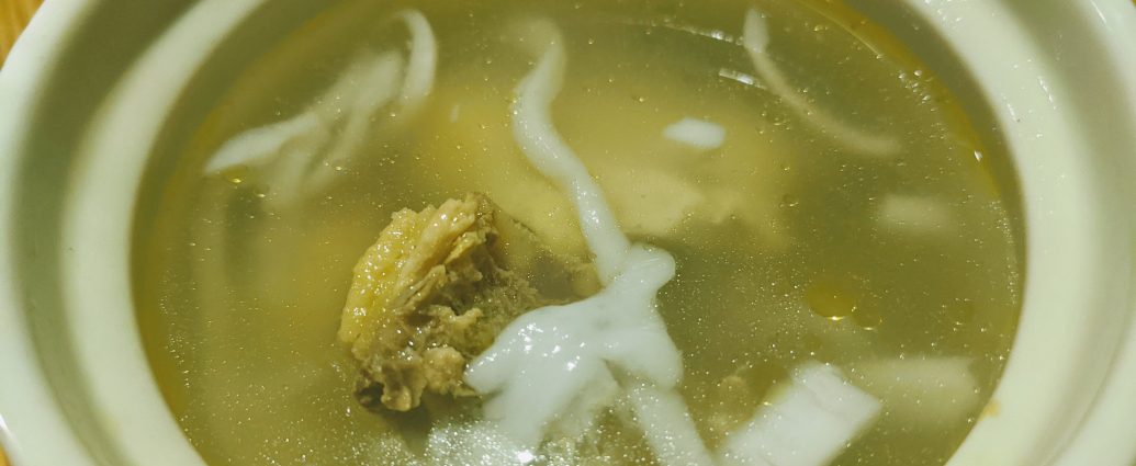 Hainanese coconut chicken soup with coconut meat and chicken in clear broth