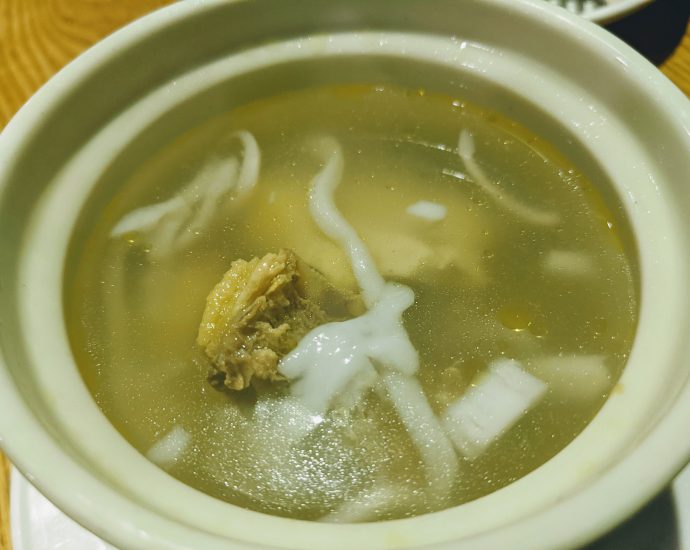 Hainanese coconut chicken soup with coconut meat and chicken in clear broth