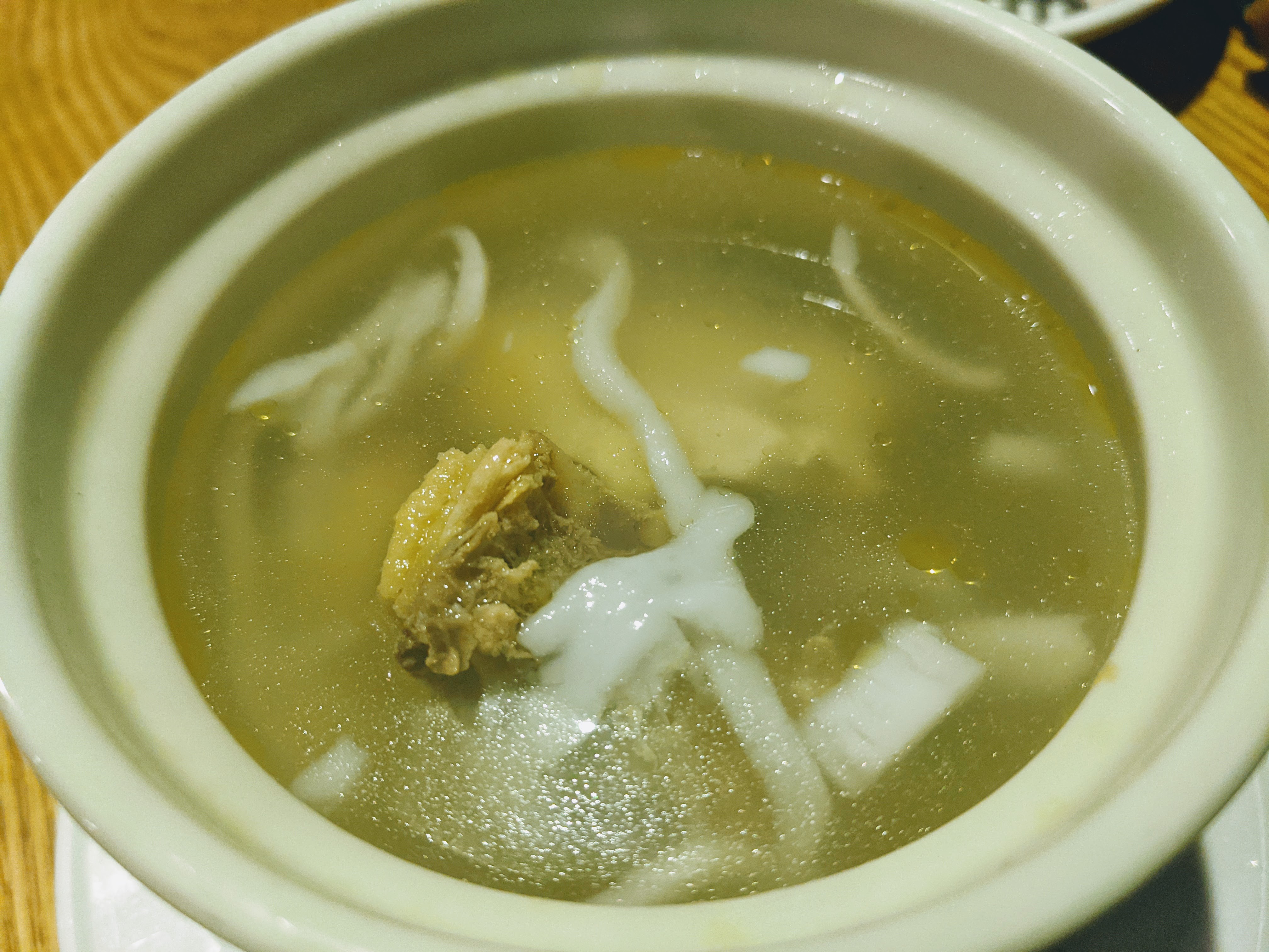 Hainanese coconut chicken soup with coconut meat, chicken, and clear golden broth
