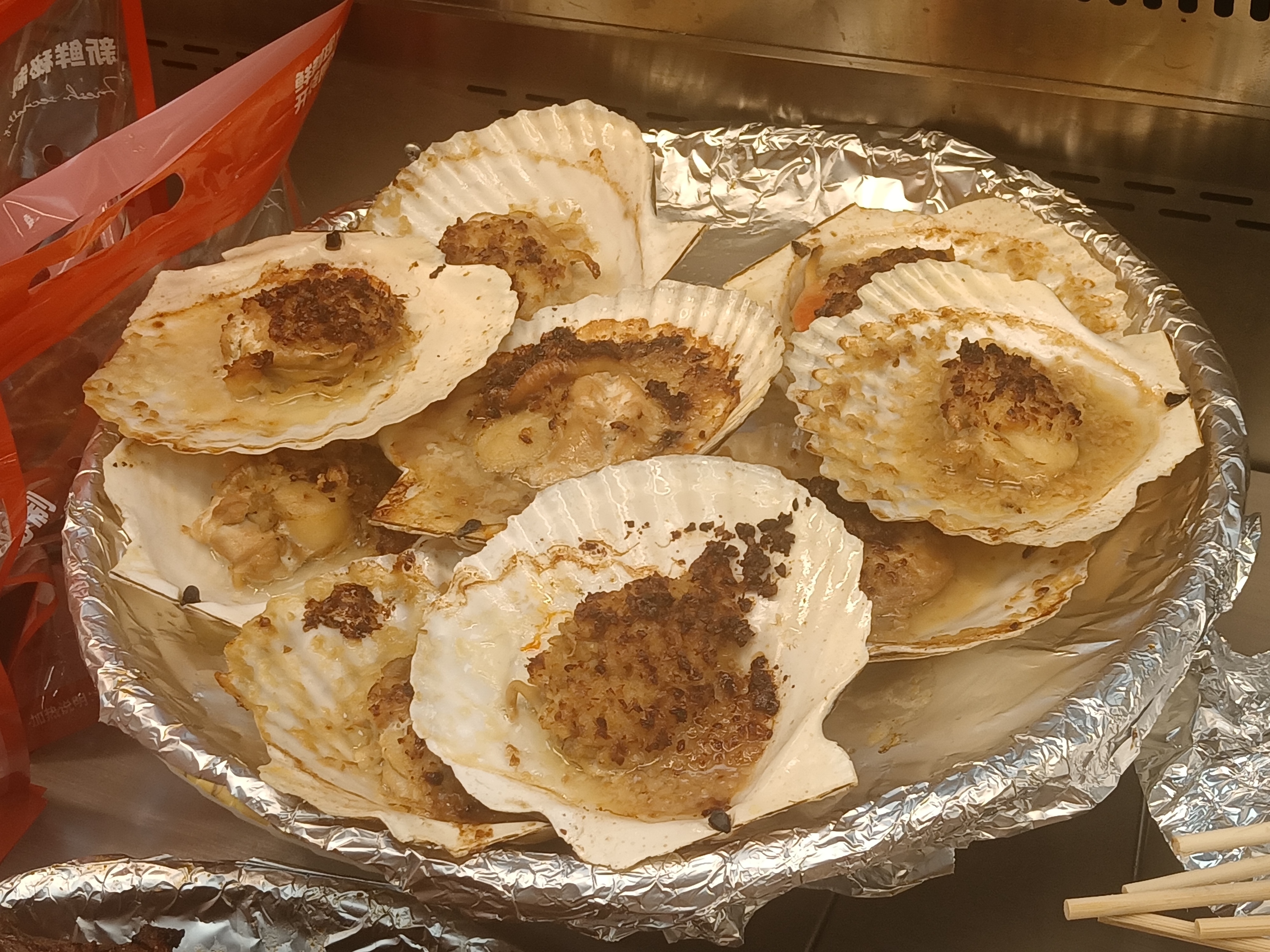 Steamed scallops on the half shell with golden garlic and glass vermicelli