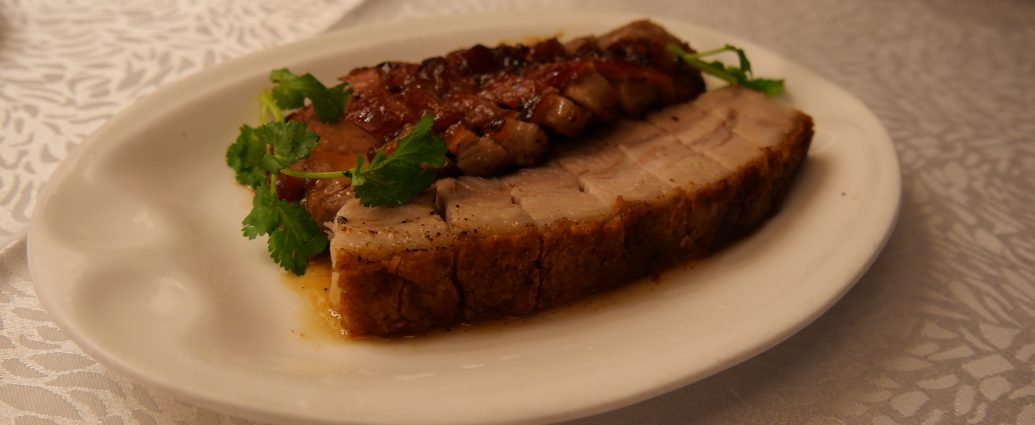 Crispy roast pork belly Siu Yuk with crackling skin at a Cantonese barbecue shop